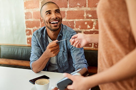 Man paying with card at restaurant.