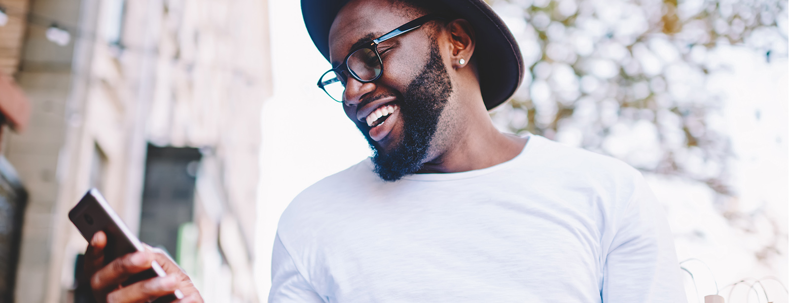 smiling man looking at cell phone