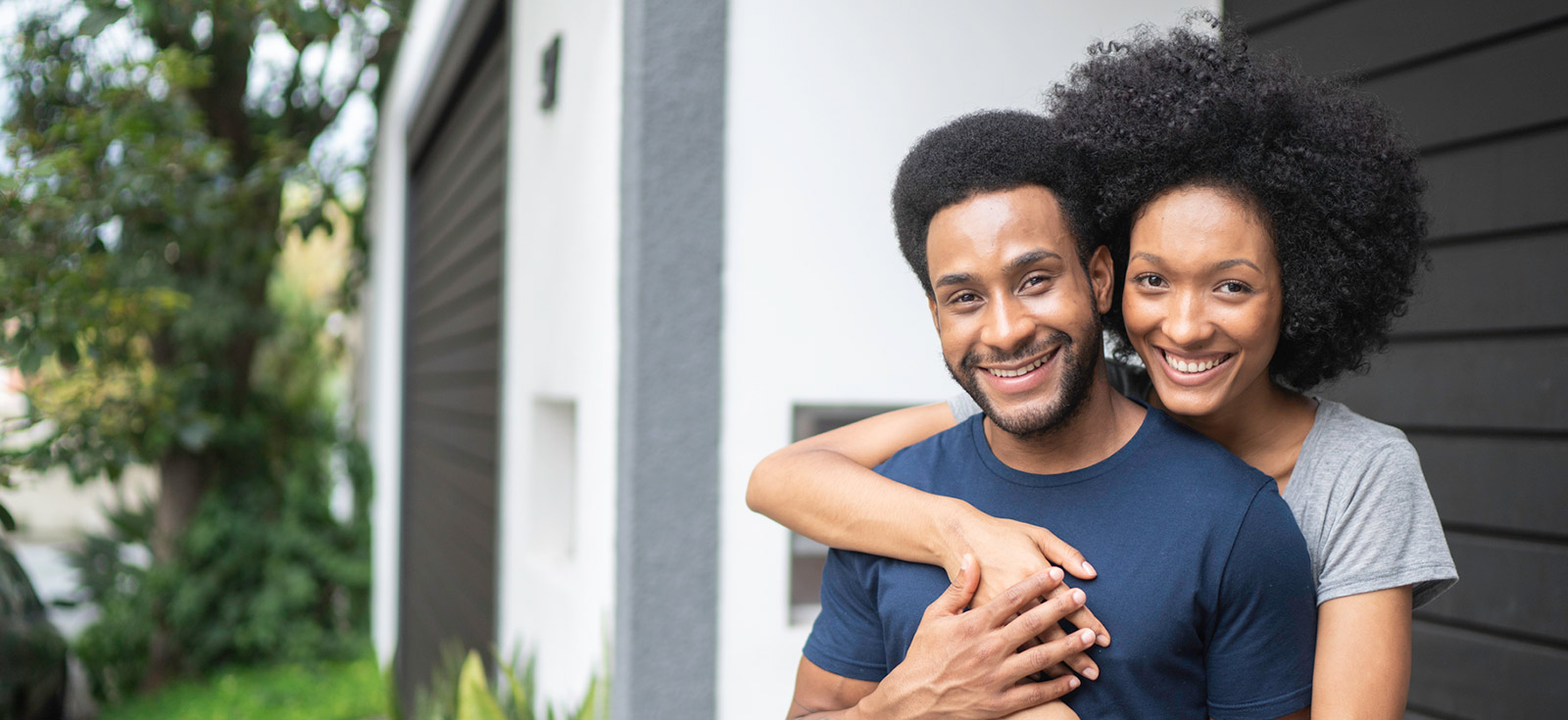 Young couple outside new home.