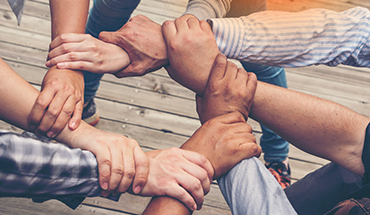 Photo of hands linked symbolizing a sense of community