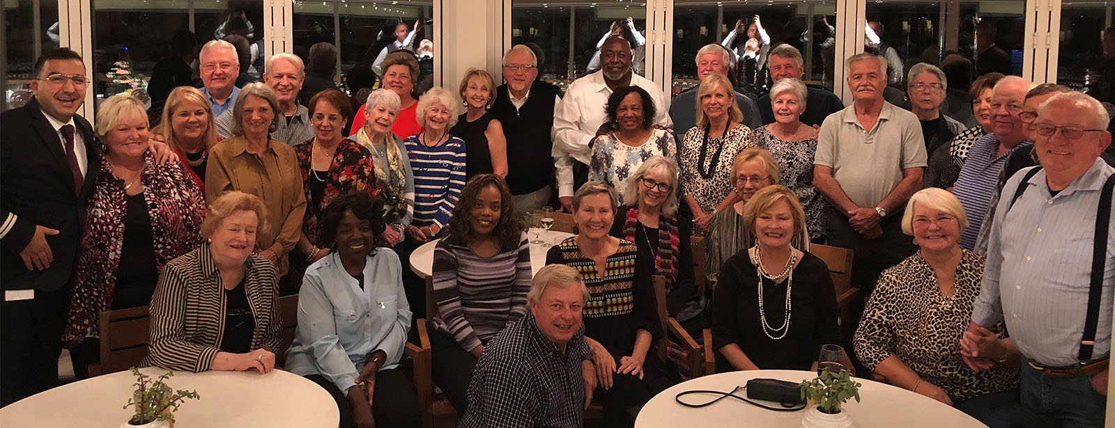 Large group of New Horizons Travelers smiling and on cruise ship dining room.