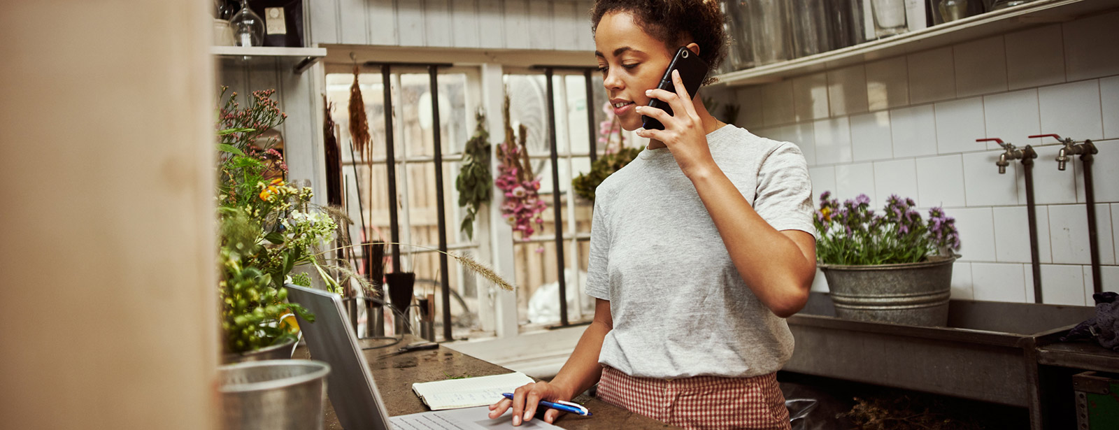 Woman on phone at laptop.