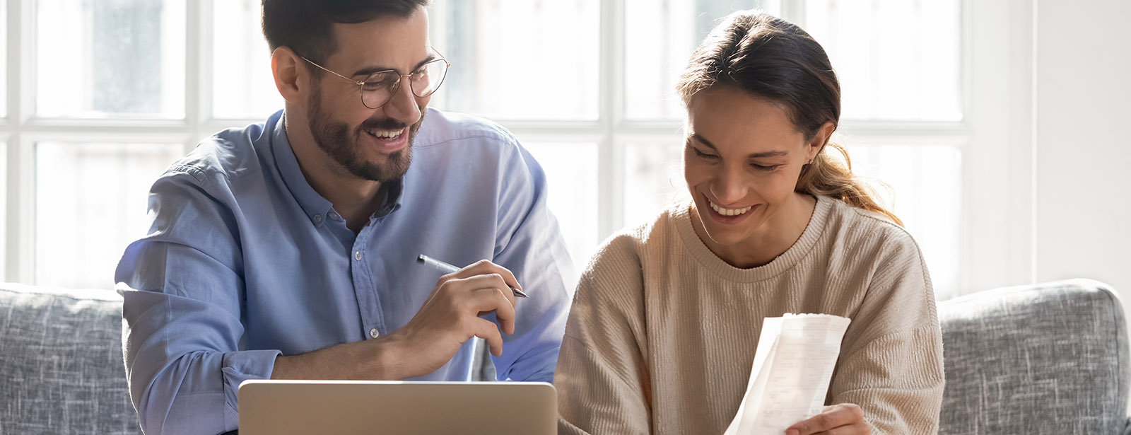 Couple smiling and paying bills